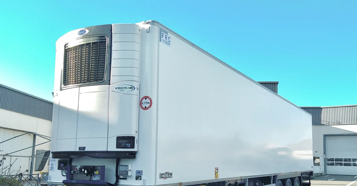 A plain white refrigerated (reefer) trailer with its cooling unit at the nose, parked on landing gear